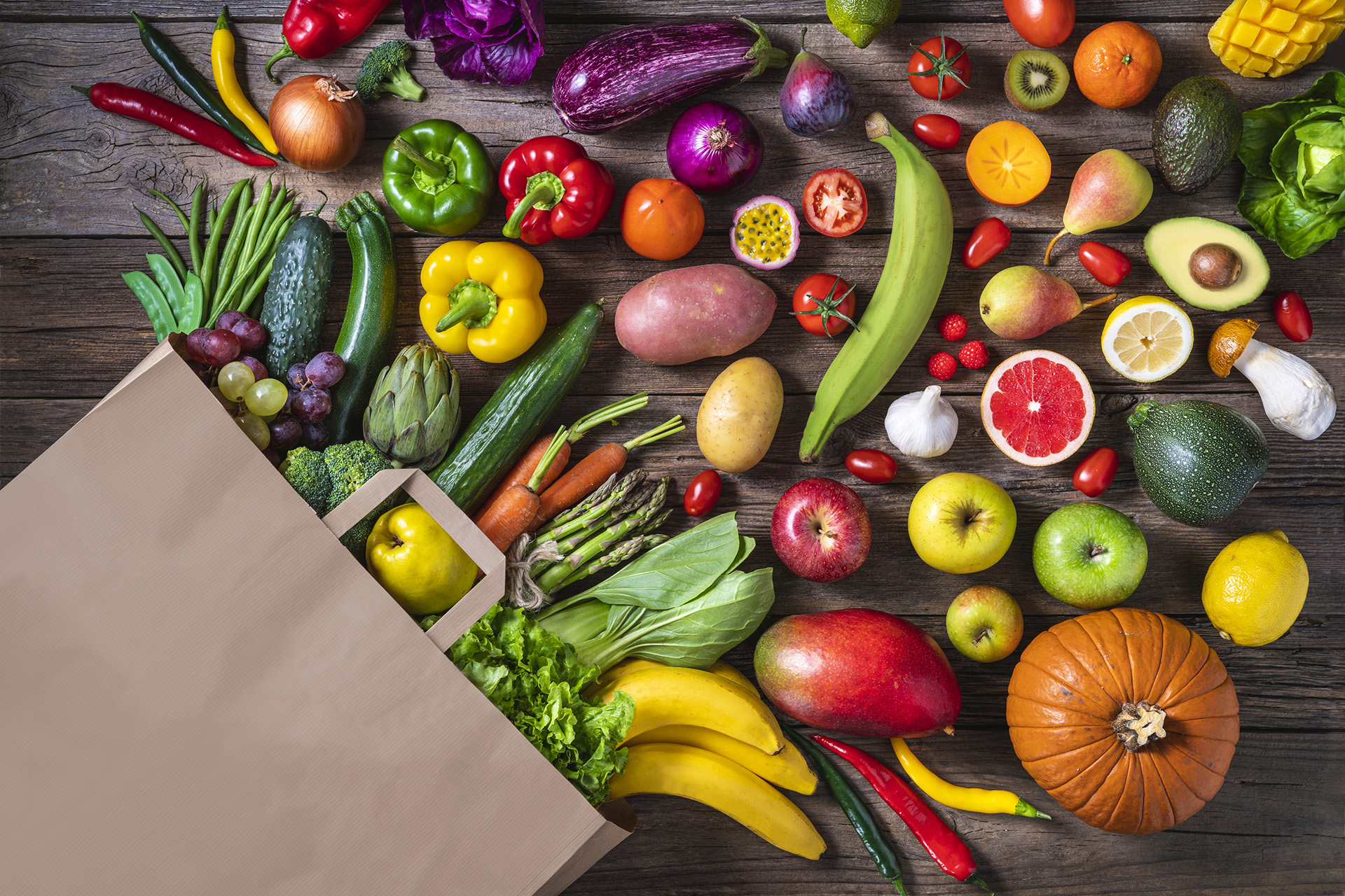 Vegan shopping bag with fruits and vegetables on wooden rustic table